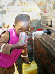 Primus, an orphan at the Mugonero Orphanage in western Rwanda, drinks the first glass of water from EWB-JSC’s water-treatment system. 