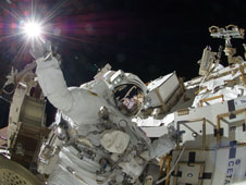 NASA Astronaut Sunita Williams appears to touch the bright sun during a third session of extravehicular activity. Williams and Japan Aerospace Exploration Agency astronaut Aki Hoshide (visible in the reflections of Williams helmet visor) completed installation of a main bus switching unit.