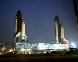 On August 9, 1990, Columbia (left) rolls out to the pad while Atlantis rolls back to the Vehicle Assembly Building.  