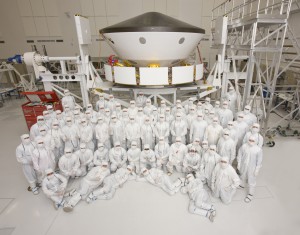 The integrated MSL spacecraft in the Spacecraft Assembly Facility at JPL along with the Assembly, Test, and Launch Operations team. Visible are the cruise stage (lower segmented ring), the backshell, and heat shield. Inside the capsule are the rover and descent stage. The capsule is 15 ft. in diameter, larger than the Apollo capsule. 