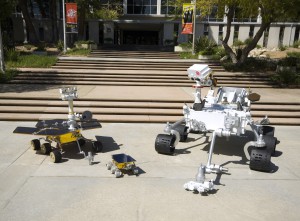 A family history of JPL Mars rovers: a full-scale model of the Sojourner rover (center) that accompanied the Mars Pathfinder lander in 1997; a model of Spirit and Opportunity, the Mars Exploration Rovers (left); and a model of the Mars Science Laboratory (right), with its seven-foot-high remote-sensing mast.  