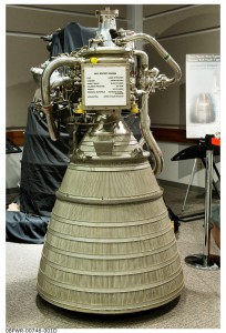 The RL10 program team displays a five-foot mock-up of the RL10 rocket engine, complete with plastic valves and combustion chambers. 