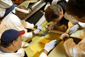 Engineers use a template and protective sheets to carefully begin dissection of the bipod ramp foam after the Columbia accident  