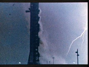 Lightning strikes near a silhouetted mobile launch tower about 36.5 seconds after the 1969 liftoff of Apollo 12, which was also struck during its ascent. This event led to updated weather criteria for governing launch decisions, but a rationale for the update was not recorded. 
