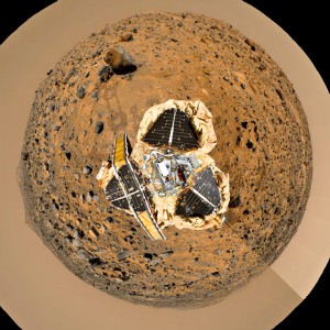 This image is a digital combination of panoramic pictures taken by Pathfinder on Mars and a picture of a lander scale model back on Earth. Sojourner itself is visible inspecting a rock nicknamed Yogi.  