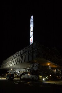 The 327-foot-tall Ares I-X test vehicle, brightly lit against the night sky, rides aboard a crawler-transporter for the 4.2-mile trip to Launch Pad 39B.  
