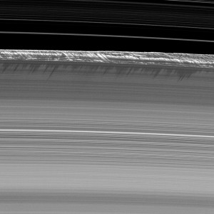 Vertical structures, among the tallest seen in Saturn’s main rings, rise abruptly from the edge of Saturn's B ring to cast long shadows on the ring. 