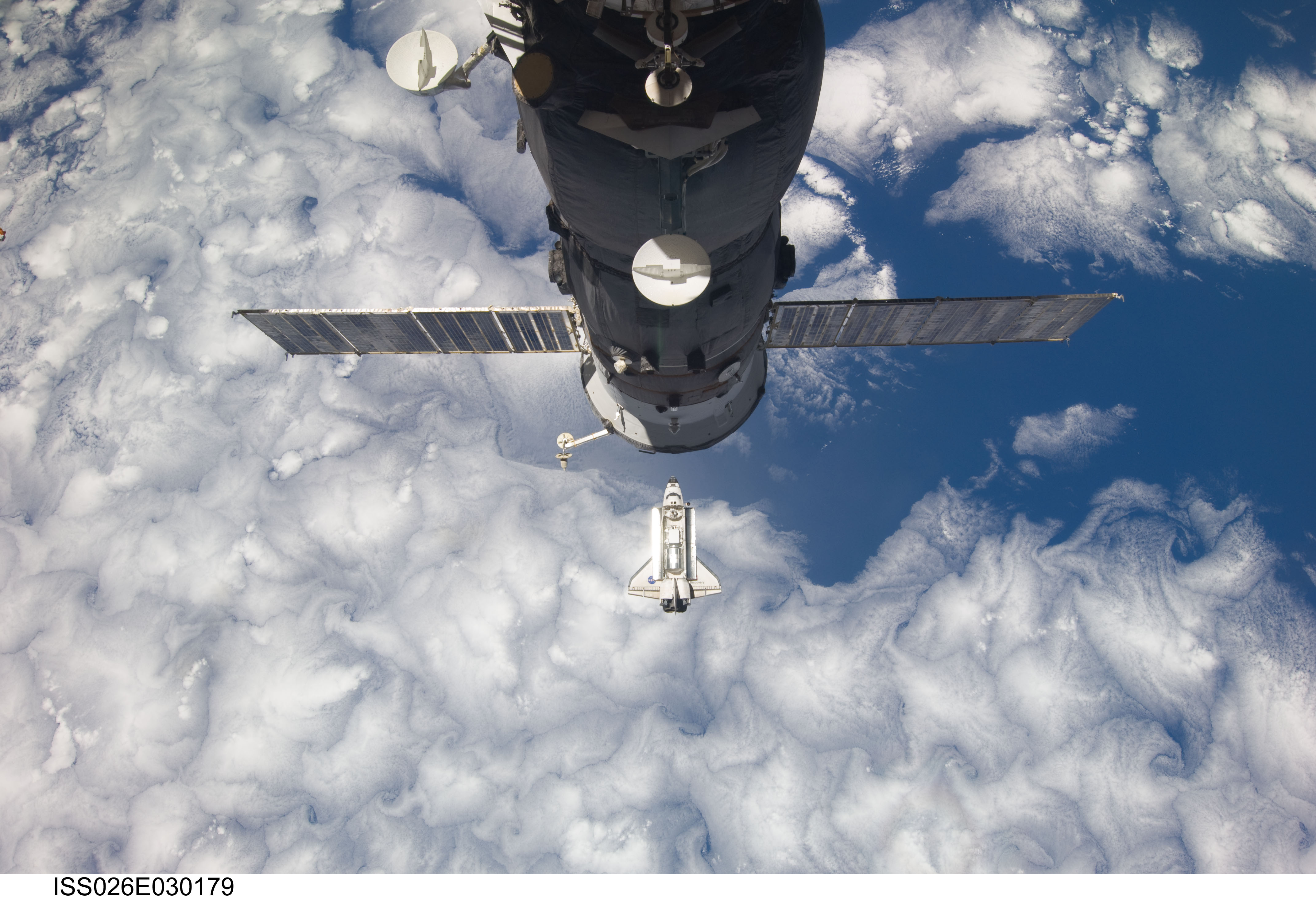 Backdropped by Earth, Discovery approaches the International Space Station