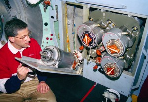 Astronaut Jay Apt looking at a solid-fuel oxygen generator like the one that caught fire on Mir.