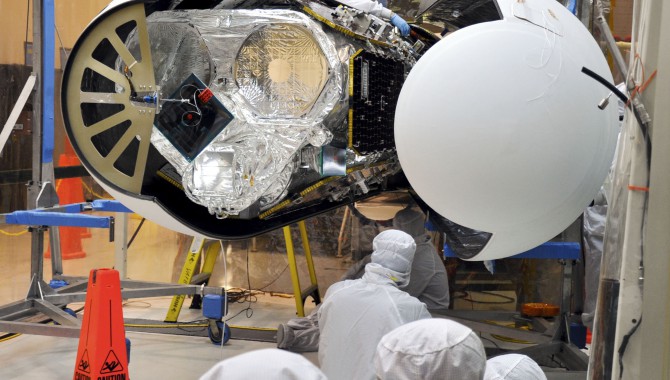 An Orbital Sciences technician completes final checks of NASA’s NuSTAR inside the Orbital processing facility before the Pegasus payload fairing is secured around it.