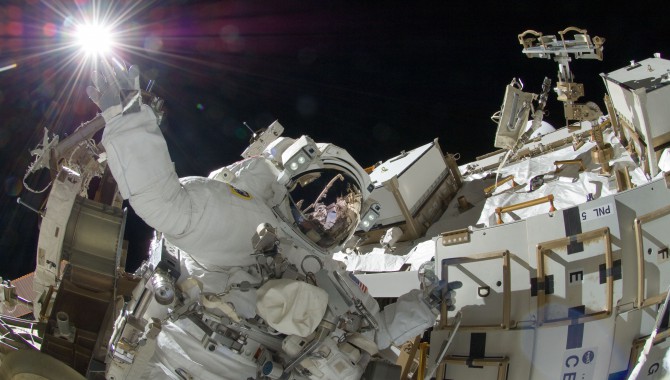 NASA Astronaut Sunita Williams appears to touch the bright sun during a third session of extravehicular activity. Williams and Japan Aerospace Exploration Agency Astronaut Aki Hoshide (visible in the reflections of Williams’ helmet visor) completed installation of a main bus switching unit. Photo Credit: NASA