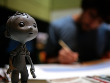 Close up of a model of the main character, a young boy, in the new Pixar short La Luna. Enrico Casarosa, director of the Oscar-nominated film, is painting using watercolor in the background.