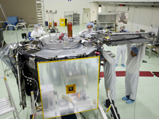 Near Kennedy Space Center, technicians inside the Astrotech payload processing facility use a crane to position the Van Allen Probes spacecraft A for stacking atop spacecraft B.