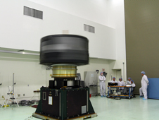Inside the Astrotech payload processing facility, technicians monitor progress as Van Allen Probe A undergoes a spin test, where the spacecraft is turned at a rate of 55 rpm to ensure it is properly balanced.