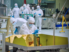 Technicians and scientists check out one of the Webb telescopes flight mirrors in the clean room at Goddard Space Flight Center.