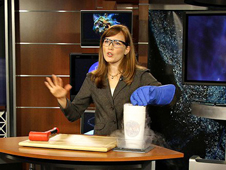 NASA Astrophysicist Amber Straughn emonstrates the cold environment where the Webb telescope will be by dipping flexible rubber surgical tubing into liquid nitrogen in a demonstration video.