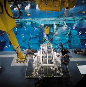 The Neutral Buoyancy Lab is a vital training ground for spacewalking astronauts. In this photo, a crew of technicians prepares two astronauts for their descent into the pool.
