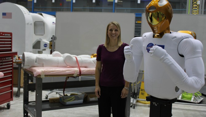 C.J. Kanelakos, mechanical engineer at Johnson Space Center, with the R2 torso and legs on the table in the background.