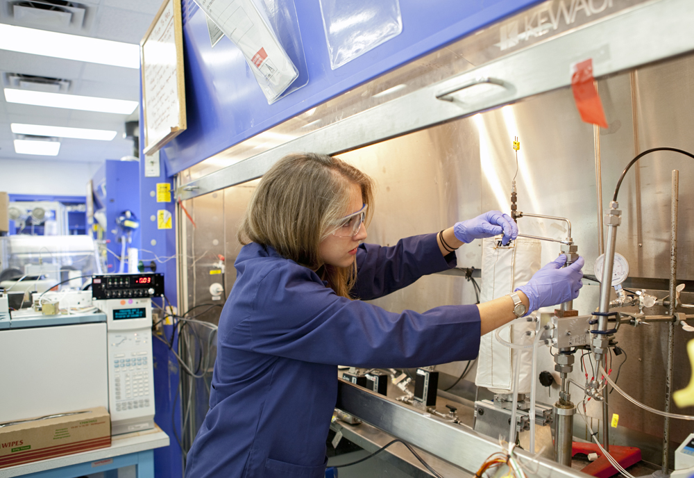 Chemist Anne Caraccio works with a prototype reactor for incinerating trash in space. The device is inside a lab at NASA's Kenendy Space Center in Florida. She is part of the team developing a mechanism to burn trash and extract valuable gases from the material.