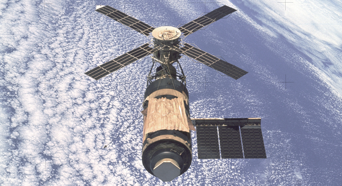 An overhead view of the Skylab Orbital Workshop in Earth orbit as photographed from the Skylab 4 Command and Service Modules (CSM) during the final fly-around by the CSM before returning home. The space station is contrasted against the pale blue Earth.