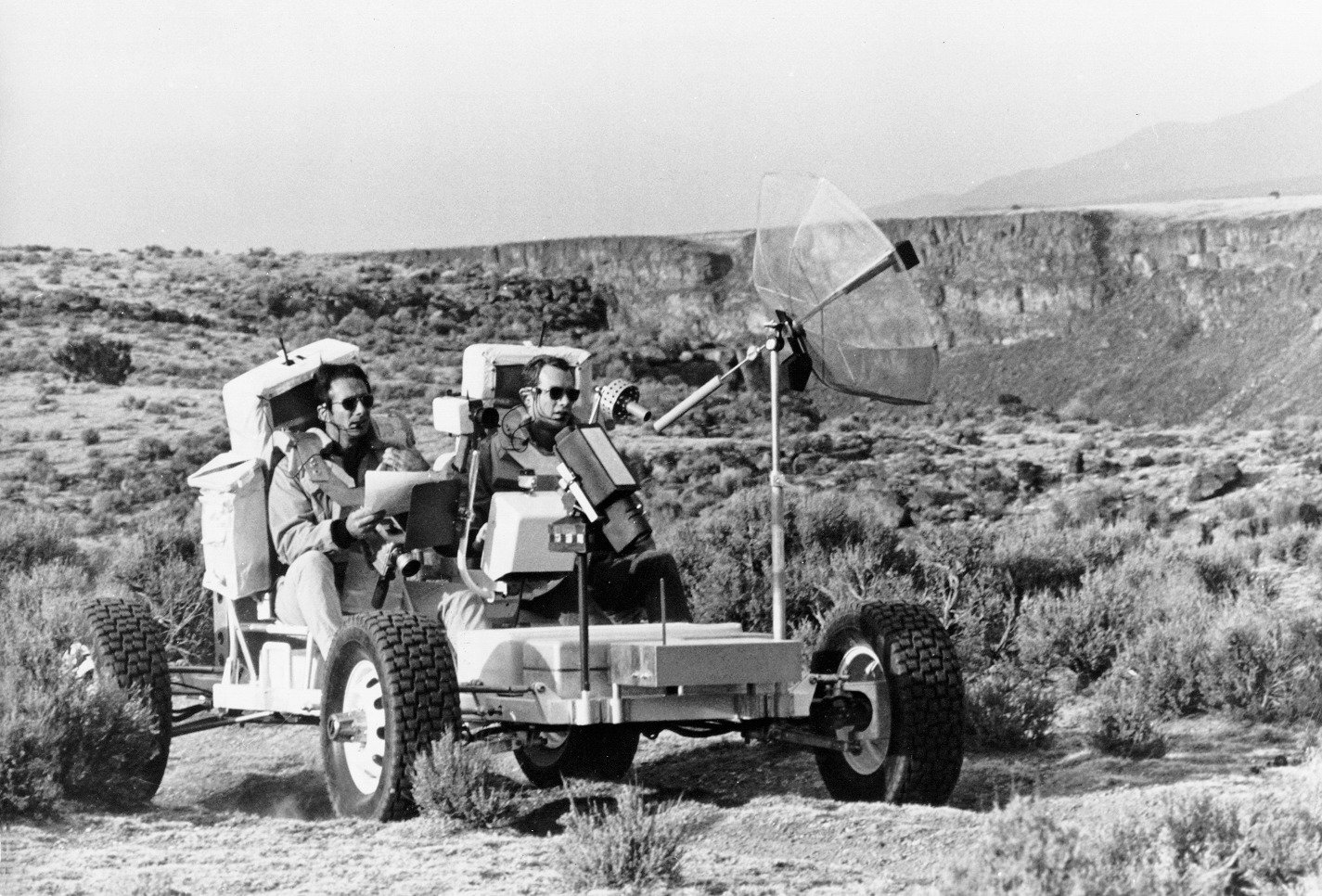 "Dave Scott (right) and Jim Irwin (left) drive the Geologic Rover ( aka Grover) along the rim of the Rio Grande Gorge at Taos, New Mexico. At this location, the Rio Grande Gorge is about the same width as Hadley Rille at the Apollo 15 landing site. During this training exercise, Dave and Jim conducted a geologic investigation similar to the one they later did at Hadley. Ulli Lotzmann notes that the 1g trainer was also known as the Geology Rover or Grover." Credit: NASA