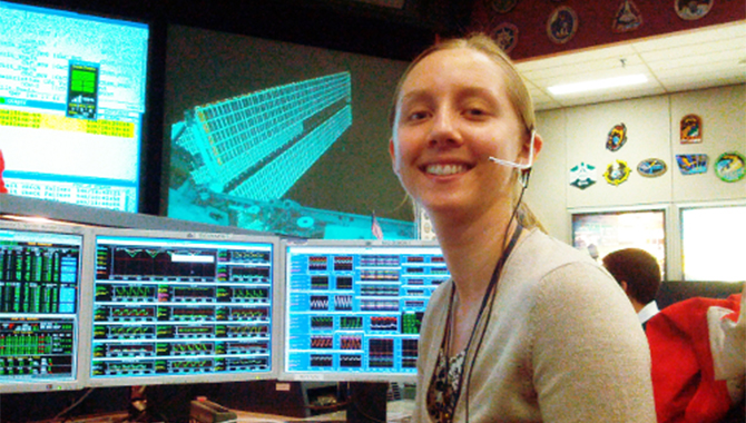 Kristen Bury sitting on the SPARTAN (Station Power, Articulation, and Thermal Control) console in Mission Control at Johnson Space Center. Photo Credit: NASA