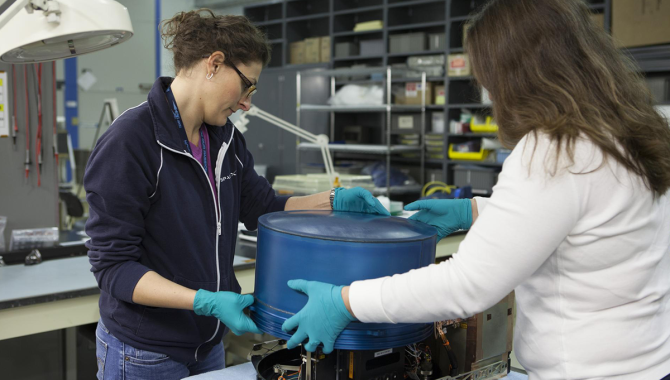 Two women preparing the Biotube experiment. Credit: NASA