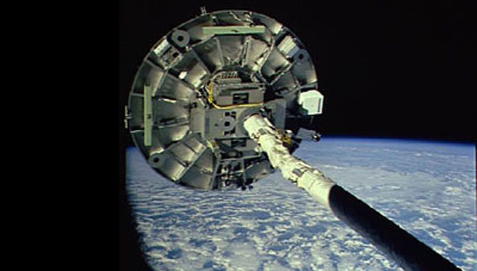 Despite problems with deployment, the Wake Shield Facility 1 was flown at the end of the shuttle’s Remote Manipulator System (RMS) mechanical arm, where it grew several thin films used to increase the processing speed of advanced electronics. Photo Credit: NASA