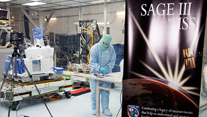 An engineer at KSC works on NASA’s Stratospheric Aerosol and Gas Experiment (SAGE) III instrument inside a super-clean “tent” designed to prevent damage to SAGE’s optics. The tent, which provides an environment that’s about 150 times cleaner than the air in an average living room, is an example of an innovative solution employed at NASA. Photo Credit: NASA/Charles Babir