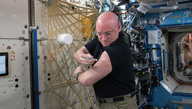 While on the International Space Station (ISS) for the One-Year Mission, NASA astronaut Scott Kelly also participated in the Twins Study, which compared his molecular information to that of his twin brother, Mark Kelly, a retired NASA astronaut who stayed back on Earth. Here, Kelly gives himself a flu shot as part of an investigation into the twins’ immune responses. Credit: NASA