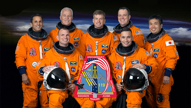Attired in training versions of their shuttle launch and entry suits, these seven astronauts take a break from training to pose for the STS-119 crew portrait. From the right (front row) are NASA astronauts Lee Archambault, commander, and Tony Antonelli, pilot. From the left (back row) are NASA astronauts Joseph Acaba, John Phillips, Steve Swanson, Richard Arnold and Japan Aerospace Exploration Agency astronaut Koichi Wakata, all mission specialists. Wakata is scheduled to join Expedition 18 as flight engineer after launching to the International Space Station on STS-119.