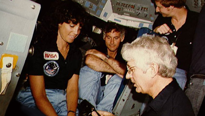 In the mock-up flight deck of a shuttle trainer, STS-41D rookie astronauts (from left) Judy Resnik, Mike Mullane and Steve Hawley (in back) work with veteran Commander Henry Hartsfield (in foreground). Image credit: NASA