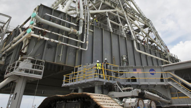 Crawler-transporter 2 (CT-2) is being moved under the mobile launcher May 31, 2018, at NASA's Kennedy Space Center in Florida. Three lifts will be performed to practice lifting procedures, validate interface locations, confirm the weight of the mobile launcher, and develop a baseline for modal analysis. The mobile launcher is equipped with a number of lines, called umbilicals, which will connect to NASA's Space Launch System (SLS) and Orion. CT-2 has been upgraded to handle the weight of the mobile launcher with SLS and Orion atop. Exploration Ground Systems is preparing the ground systems necessary to support the SLS and Orion spacecraft for Exploration Mission-1 and deep space missions. Credit: NASA