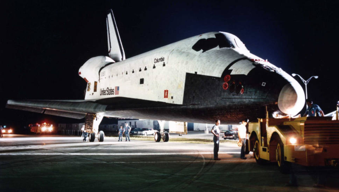 At NASA’s Kennedy Space Center in Florida, workers tow the space shuttle orbiter Columbia from the Orbiter Processing Facility to the Vehicle Assembly Building (VAB). Credit: NASA