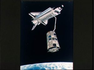 Artist concept shows STS-32 Columbia drifting above Earth's surface and the Long Duration Exposure Facility (LDEF) with payload bay doors open and the remote manipulator system (RMS) arm deployed and positioned to grapple LDEF. Credit: NASA/LaRC