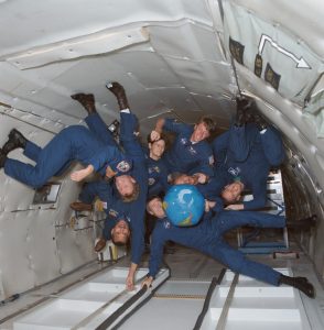 The crew of STS-45 is training in the KC-135 zero-gravity-simulating aircraft. Shown with an inflatable globe are, clockwise from the top, C. Michael Foale, mission specialist; Dirk Frimout, payload specialist; Brian Duffy, pilot; Charles R. (Rick) Chappell, backup payload specialist; Charles F. Bolden, mission commander; Byron K. Lichtenberg, payload specialist; and Kathryn D. Sullivan, payload commander.<br /> Credit: NASA