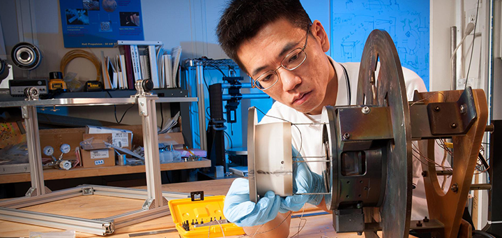 Environmental Portrait of Research Engineer Wensheng Huang working on a Hall thruster in the Electric Propulsion Laboratory at NASA Glenn Research Center. Credit: NASA