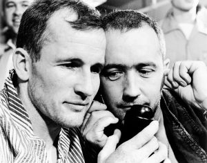 The Gemini-4 prime crew, astronauts Edward H. White II (left), pilot; and James A. McDivitt, command pilot, listen to the voice of President Lyndon B. Johnson on June 7, 1965, as he congratulated them by telephone on their successful four-day, 62-revolution Gemini-4 mission. Credit: NASA