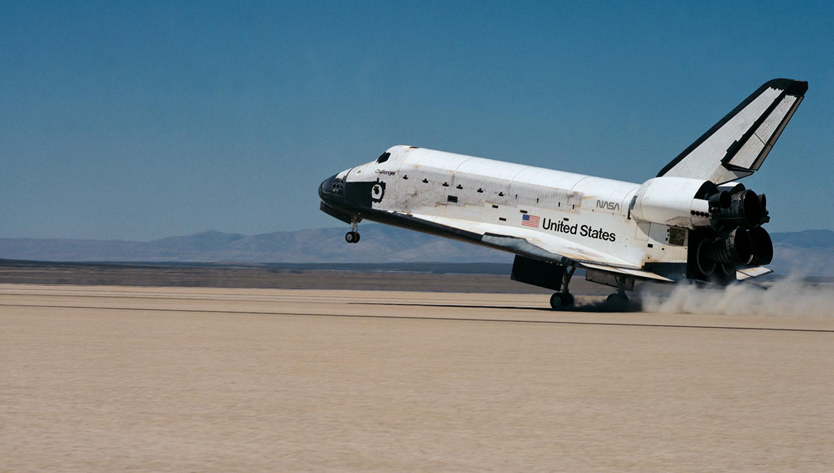 The Space Shuttle Challenger, with its seven member crew and battery of scientific experiments aboard, eases its rear landing gear onto the dry lake bed at Edwards Air Force Base in California, completing STS-51-F. Credit: NASA