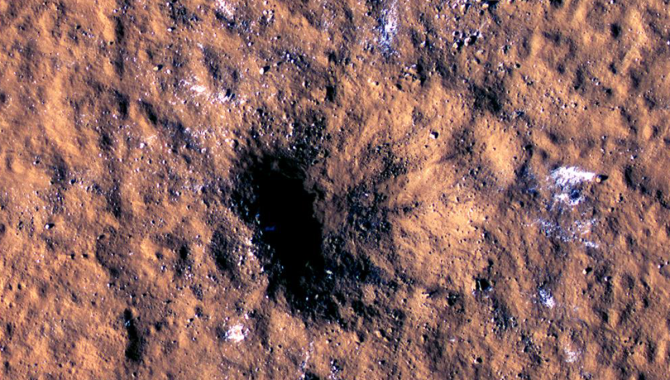 A meteoroid slammed into the surface of Mars on December 24, 2021, leaving this massive crater and ejecting boulders of water ice across a wide area. In the months that followed, two NASA teams pieced together what the impact was and what it reveals about the planet’s crust. Credit: NASA/JPL-Caltech/University of Arizona