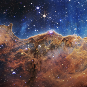 This landscape of “mountains” and “valleys” speckled with glittering stars is actually the edge of a nearby, young, star-forming region called NGC 3324 in the Carina Nebula. Captured in infrared light by NASA’s new James Webb Space Telescope, this image reveals for the first time previously invisible areas of star birth. Credit: NASA
