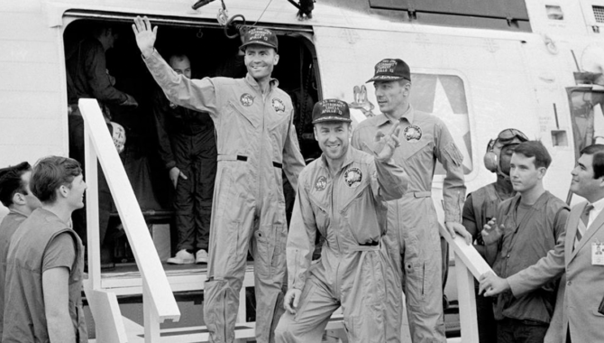 The crew members of the Apollo 13 mission step onto the deck of the U.S.S. Iwo Jima, following splashdown and recovery operations in the South Pacific Ocean. Aboard the ship, Fred W. Haise Jr., lunar module pilot (left); James A. Lovell, Jr., commander (center); and John L. Swigert, Jr., command module pilot, discussed writing an account of the perilous spaceflight. Credit: NASA