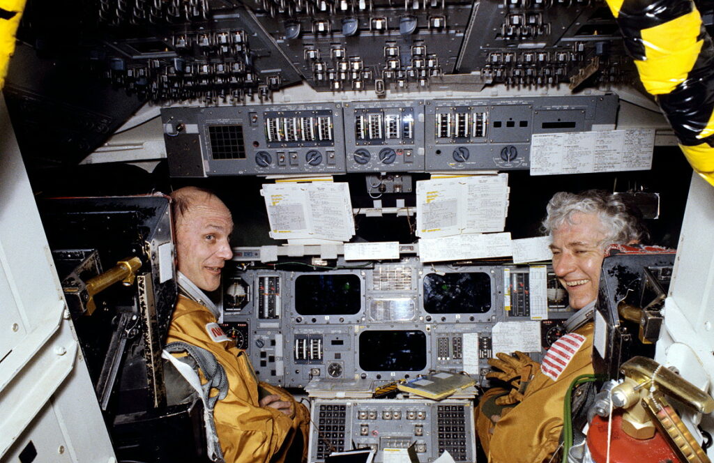 Astronauts Thomas K. “Ken” Mattingly II, (left) and Henry “Hank” Hartsfield, Jr., STS-4 commander and pilot, respectively, get in some training time in the motion base Shuttle Mission Simulator (SMS) at the Johnson Space Center's Mission Simulations and Training Facility. Photo Credit: NASA