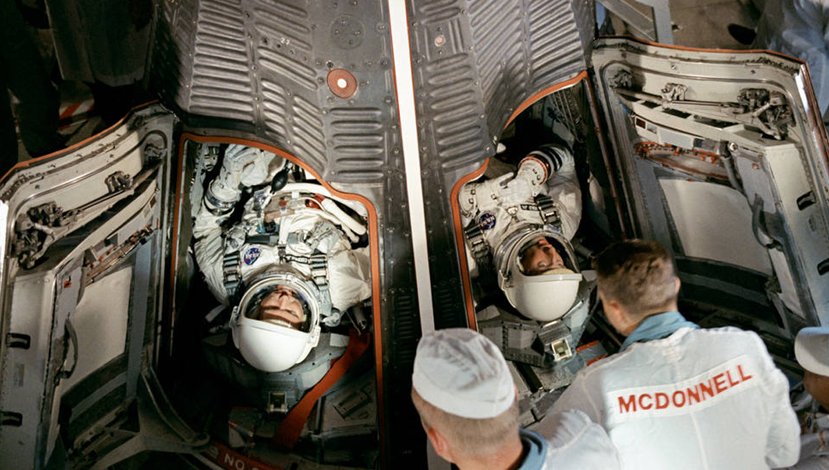 Workers in the White Room at Launch Pad 19 help L. Gordon Cooper, Jr., left, and Charles “Pete” Conrad strap in to Gemini V. The two would share the record for longest spaceflight for about four months. Photo Credit: NASA