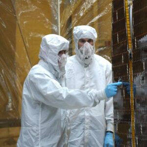 Inside the clean-room "tent" of Building 1555 at North Vandenberg Air Force Base, technicians in bunny suits prepare for the solar array deployment on the AIM spacecraft. Photo Credit: NASA
