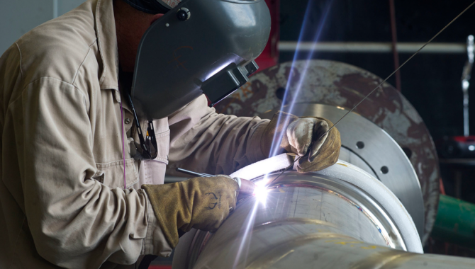 In this photo from 2013, a welder at NASA’s Stennis Space Center works on a portion of piping to be installed on the A-1 Test Stand for RS-25 rocket engine testing. Photo Credit: NASA/MSFC