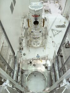 Ready for transportation to the Kennedy Space Center, the Hubble Space Telescope (HST) is pictured onboard the strongback dolly at the Vertical Processing Facility (VPF) at the Lockheed assembly plant upon completion of final testing and verification. Photo Credit: NASA