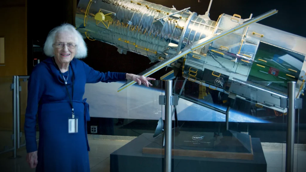 Dr. Nancy Grace Roman stands next to a scale model of the Hubble Space Telescope outside the Hubble control center at NASA’s Goddard Space Flight Center in Greenbelt, Maryland. Roman is known as the “Mother of Hubble.” Photo Credit: NASA