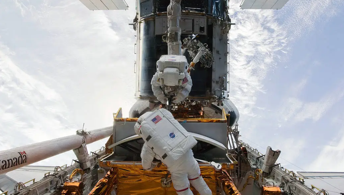 Astronauts John Grunsfeld and Andrew Feustel perform the first of five spacewalks scheduled on STS-125 to upgrade and extend the working life of the Hubble Space Telescope. Photo Credit: NASA