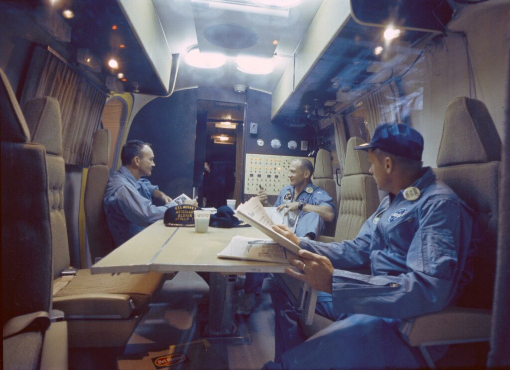 With the June 6 announcement that Apollo 11 would be the first attempt at a human lunar landing, the crew of the USS Hornet was trained on NASA’s contamination containment process, which included the Mobile Quarantine Facility (MQF), which was placed on the ship. In this photo, from left, Michael Collins, Edwin “Buzz” Aldrin, and Neil Armstrong relax following the mission. Photo Credit: NASA